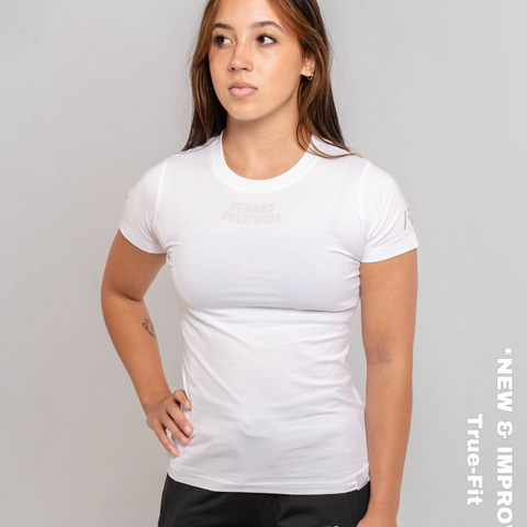 Woman wearing A7's IPF Approved Polar white Meet shirt. 'Demand Greatness’ written on the front of white meet t-shirt in a grey double outlined font to have impact on the competition platform. Paired with black powerlifting joggers made from a stretchy material to use in strength sports training. 