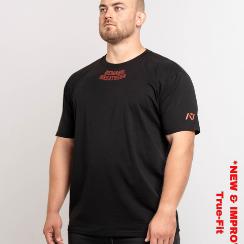 Man wearing A7's IPF Approved Red Dawn Meet shirt. 'Demand Greatness’ written on the front of black meet t-shirt in a red double outlined font to have impact on the competition platform. Paired with black powerlifting joggers made from a stretchy material to use in strength sports training. 