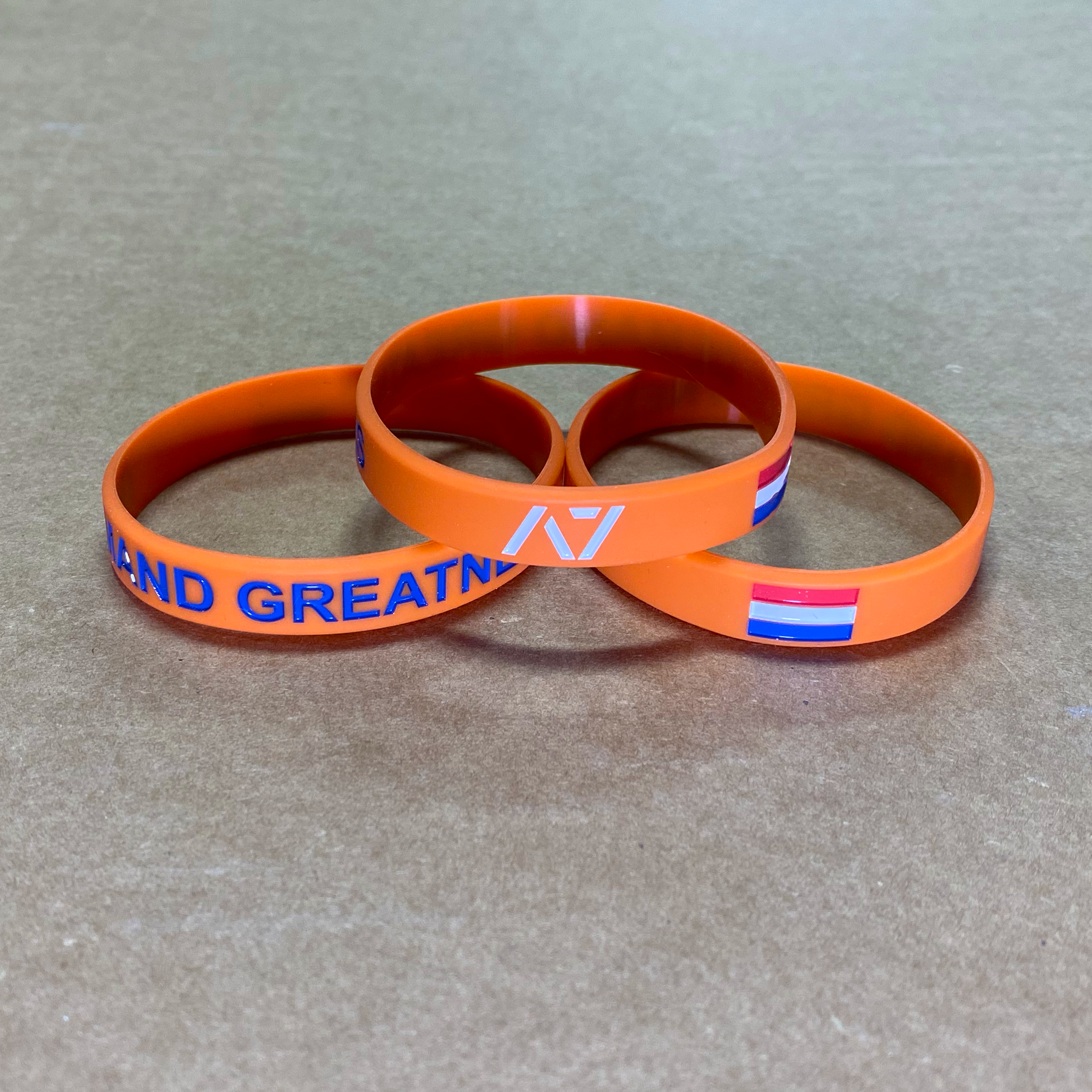 You are always working towards your goals and helping others reach their full potential. Feel the Dutch spirit with this country wristband design that incorporates the Dutch flag into a wristband and reminds you to always Demand Greatness. The wristband is 1/2 inch wide and features black debossed lettering.